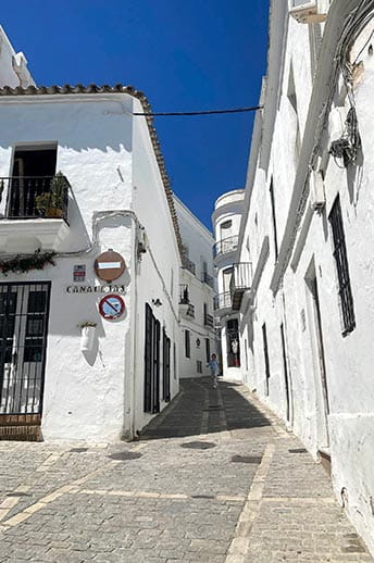 A narrow cobbled street, lined with white buildings in Cadiz, Spain